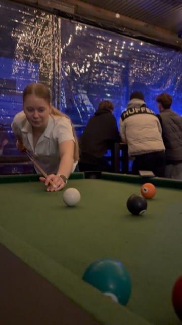 Someone lining up a shot at a pool table.