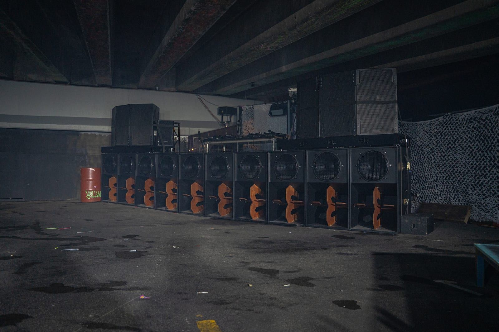 The empty venue before doors: a wall of speakers under the concrete ceiling.
