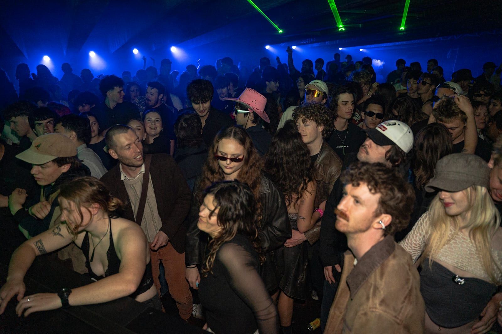Crowd dancing close to the front in blue light.